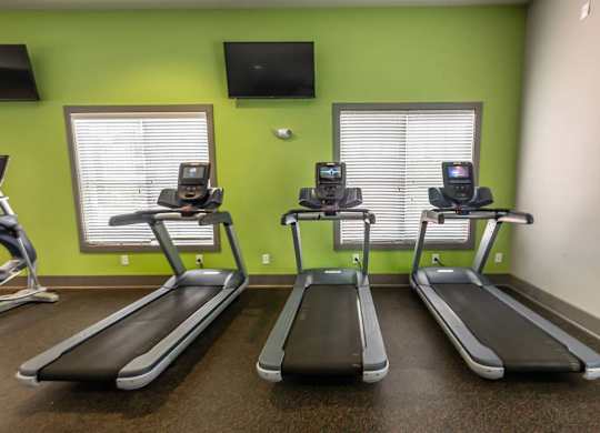 Three treadmills are lined up in a row in a gym at Foxwood Apartments, Raleigh-Durham, NC, 27616