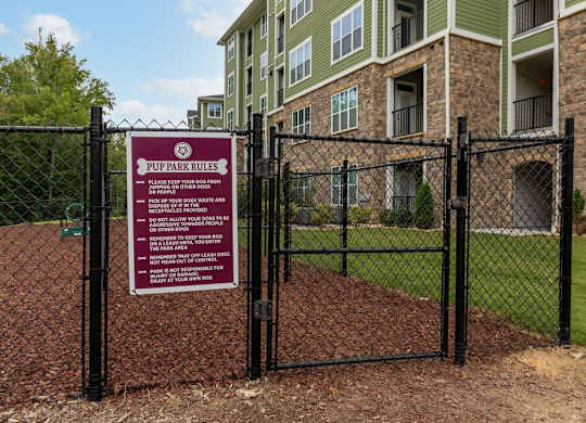A sign in front of a building that says PUP PARK RULES at Foxwood Apartments, Raleigh-Durham