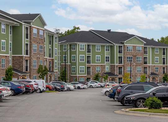 A parking lot with cars and apartment buildings in the background at Foxwood Apartments, Raleigh-Durham, 27616