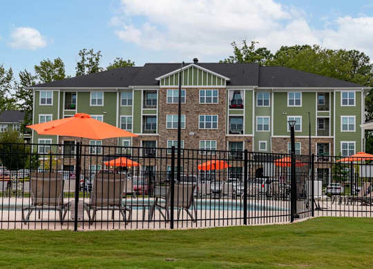 A large building with a pool in front of it at Foxwood Apartments, Raleigh-Durham, NC