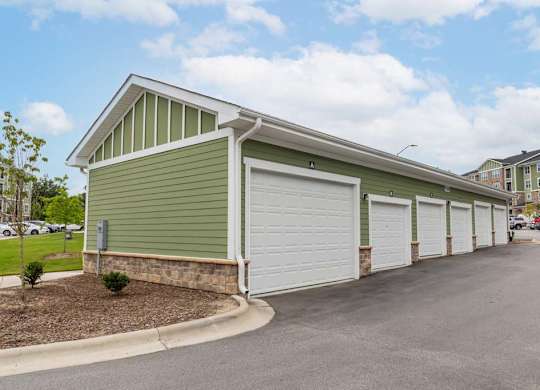 A green building with a white garage door at Foxwood Apartments, Raleigh-Durham