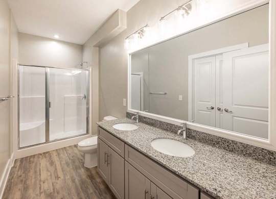 A bathroom with a toilet, sink, and mirror at Foxwood Apartments, Raleigh-Durham, 27616