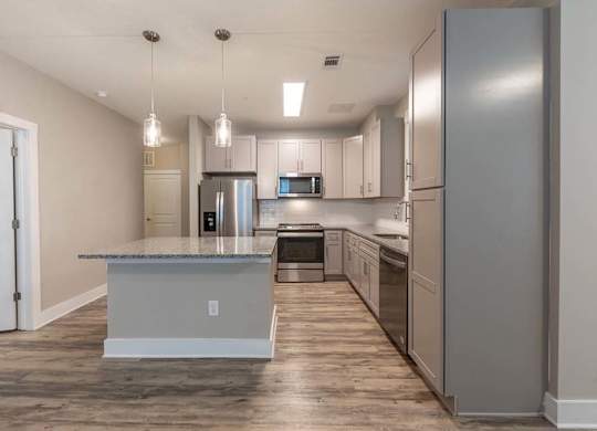 A kitchen with a granite countertop and stainless steel appliances at Foxwood Apartments, Raleigh-Durham, North Carolina