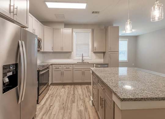 A kitchen with a granite countertop and stainless steel appliances at Foxwood Apartments, Raleigh-Durham, North Carolina