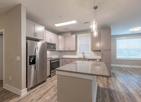 A kitchen with a granite countertop and stainless steel appliances at Foxwood Apartments, Raleigh-Durham