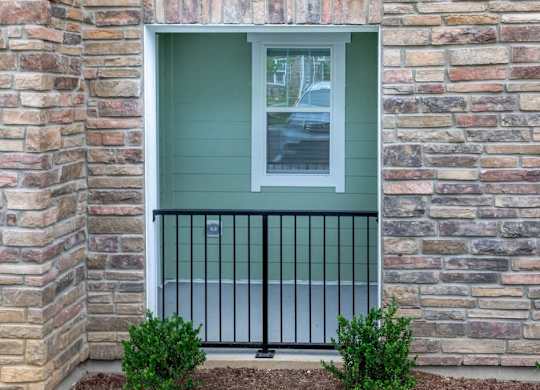 A window with a black iron railing and a green wall at Foxwood Apartments, North Carolina, 27616