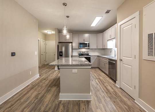A kitchen with a center island and a microwave above it at Foxwood Apartments, Raleigh-Durham, 27616
