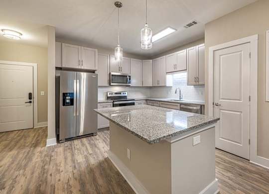 A kitchen with a granite countertop and stainless steel appliances at Foxwood Apartments, North Carolina, 27616