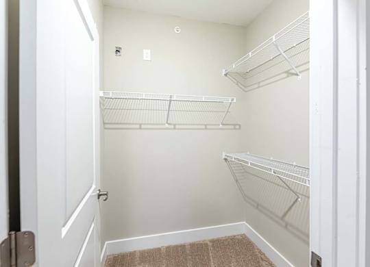 A white closet with a brown rug on the floor at Foxwood Apartments, North Carolina, 27616