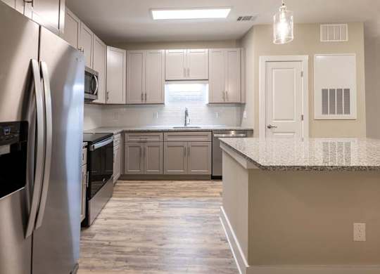 A kitchen with a refrigerator, microwave, and cabinets at Foxwood Apartments, North Carolina