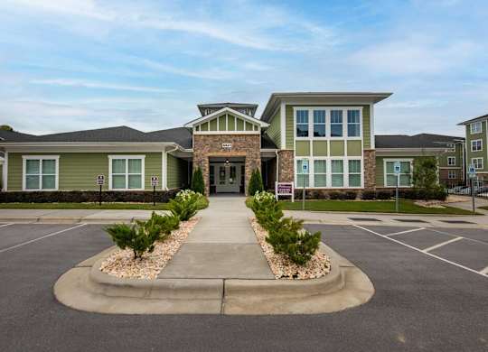 A building with a grey roof and a sign in front of it at Foxwood Apartments, Raleigh-Durham, North Carolina
