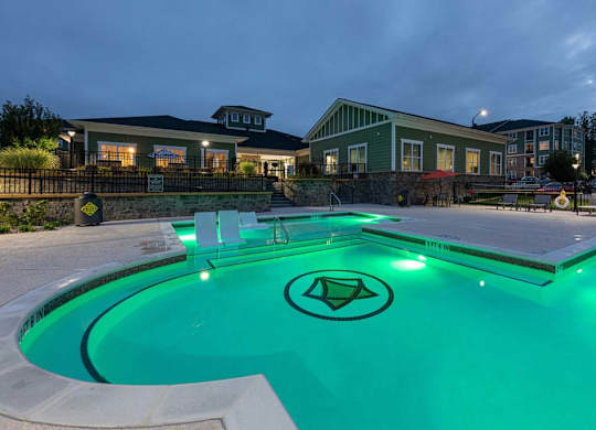 A swimming pool with a greenish tint and a logo in the middle at Foxwood Apartments, Raleigh-Durham, 27616