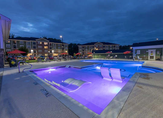 A lit up swimming pool at night. at Foxwood Apartments, Raleigh-Durham, NC, 27616