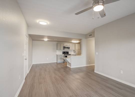 A spacious room with a ceiling fan and light fixture.