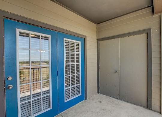 A blue door with a window and a grey door.