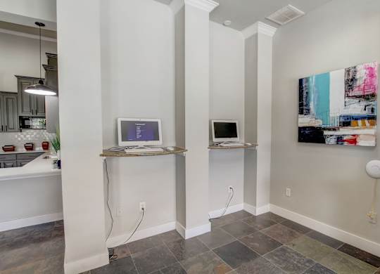 A room with a computer on a shelf and a painting on the wall.