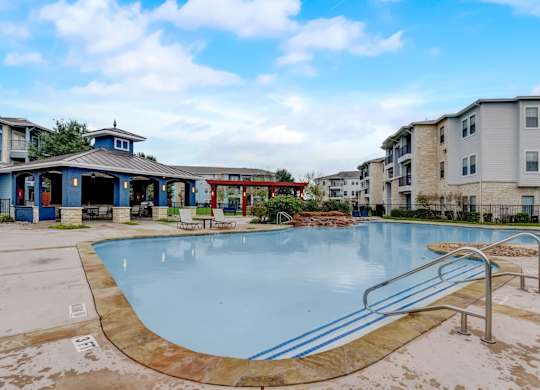 A swimming pool surrounded by a metal railing and a small building.
