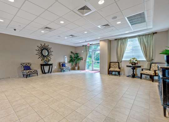 A spacious room with a tiled floor and a large mirror on the wall.