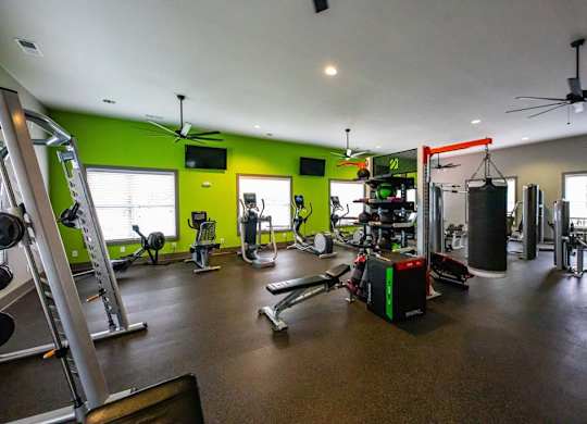 A gym with a variety of equipment including weights and cardio machines at Foxwood Apartments, North Carolina, 27616