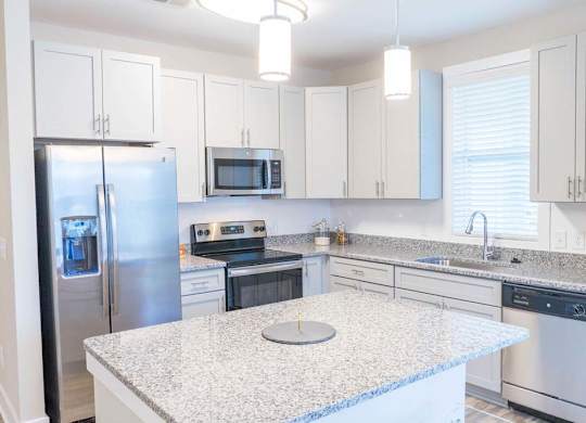 A kitchen with a granite countertop and stainless steel appliances. at Foxwood Apartments, North Carolina