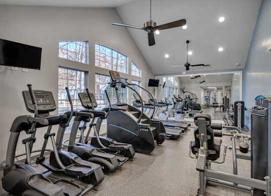 A gym with treadmills, elliptical machines, and other exercise equipment.