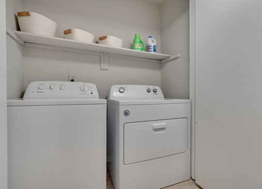 A white washing machine and dryer in a small laundry room.