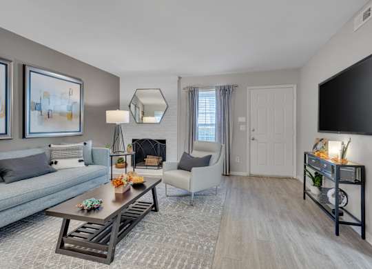 A living room with a grey couch, a coffee table, and a fireplace.