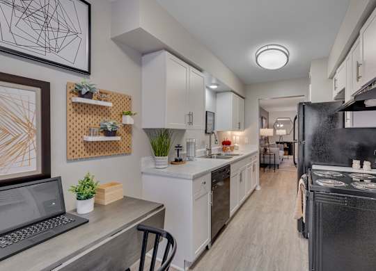 A modern kitchen with a laptop on the counter.