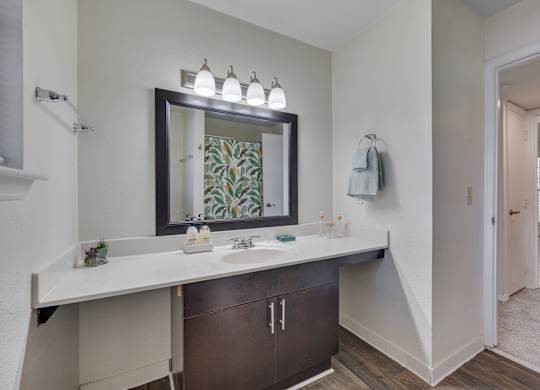A bathroom with a large mirror and a sink.