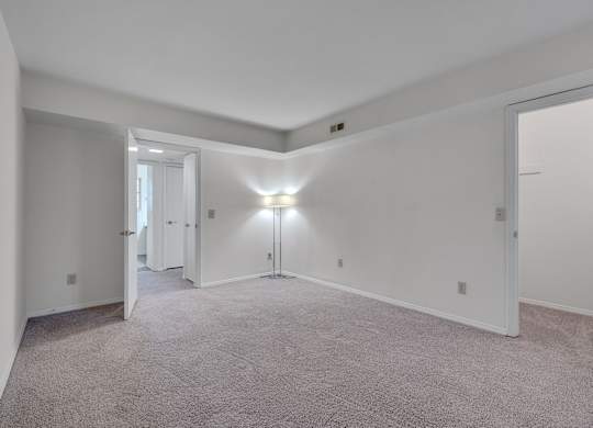 A large, empty room with carpeted floors and white walls.