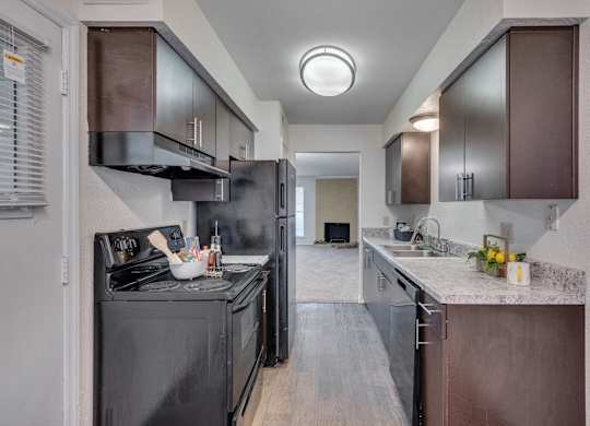 A modern kitchen with dark wood cabinets and a black stove top oven.