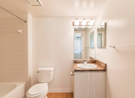 A white toilet sits next to a sink in a bathroom.