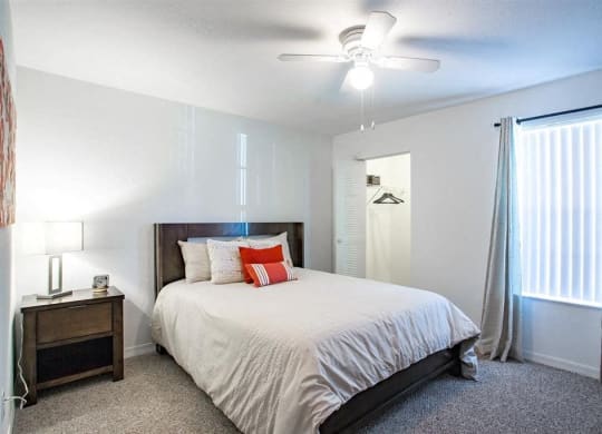 a bedroom with a bed and a ceiling fan