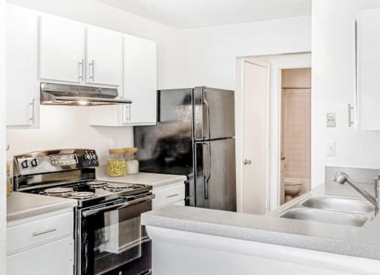 a kitchen with white cabinets and stainless steel appliances at Bridges at Mallard Creek Apartment Homes, North Carolina