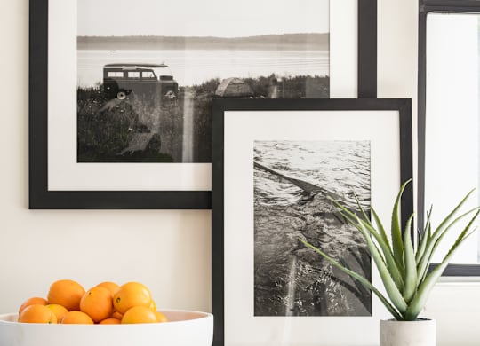 a kitchen with black and white pictures on the wall and a bowl of oranges on the counter at Bridges at Mallard Creek Apartment Homes, Charlotte