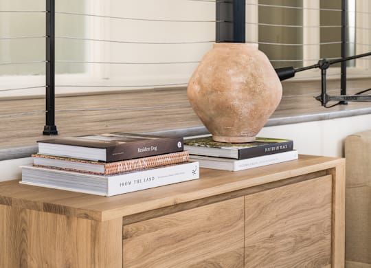 a table with books and a vase on top of it at Bridges at Mallard Creek Apartment Homes, Charlotte, 28269