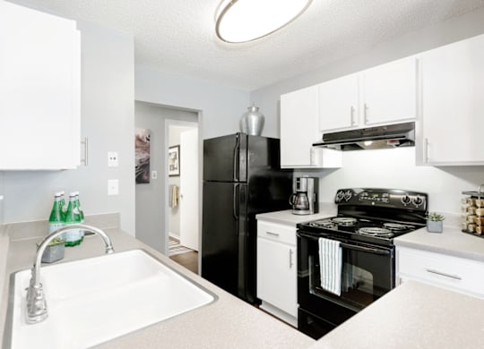 a kitchen with white cabinetry and black appliances at Bridges at Mallard Creek Apartment Homes, Charlotte, NC, 28269