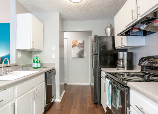 a kitchen with white cabinets and black appliances at Bridges at Mallard Creek Apartment Homes, North Carolina, 28269