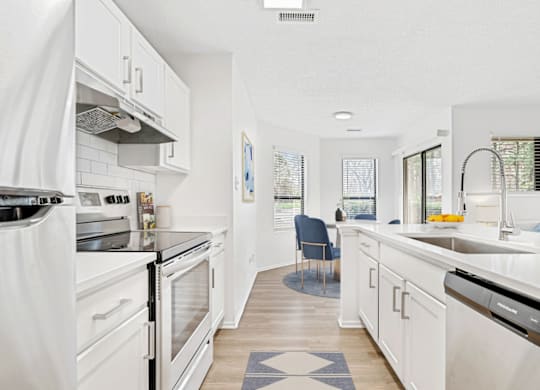 a kitchen with white cabinets and stainless steel appliances at Bridges at Mallard Creek Apartment Homes, North Carolina, 28269