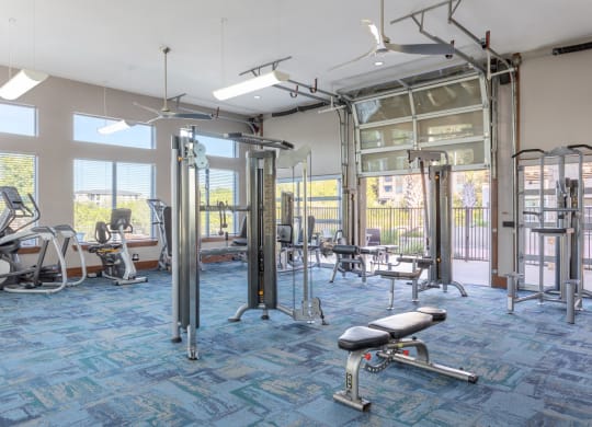 a gym with exercise equipment and windows
