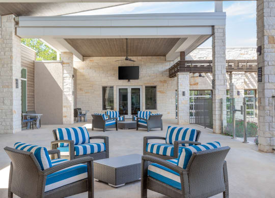 an outdoor patio with blue and white chairs and a television