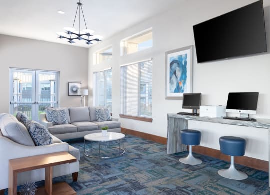 business center with computers, a television, and sofas