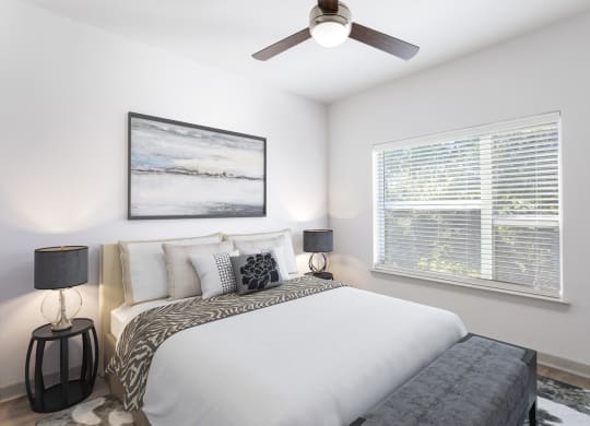 a bedroom with a large bed and a ceiling fan