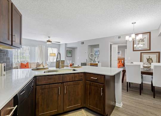 A kitchen with brown cabinets and a white counter.