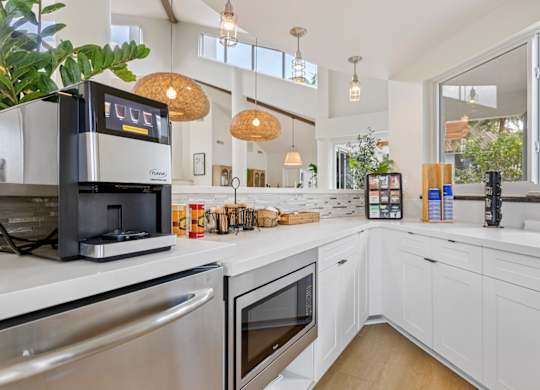 clubhouse kitchen with white cabinets and stainless steel appliances.