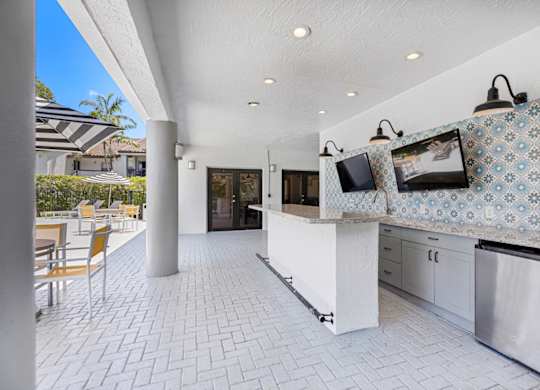 covered outdoor kitchen with TVs