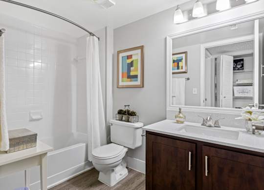 A white bathroom with a toilet, sink, and shower.