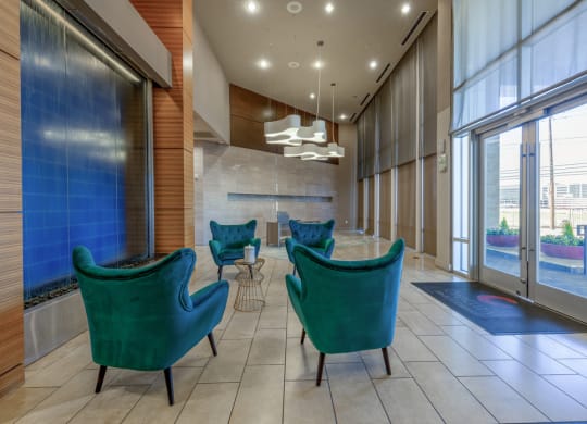 a lobby with chairs and a table and large windows