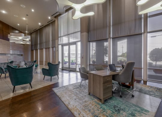 a large lobby with chairs and a desk and windows