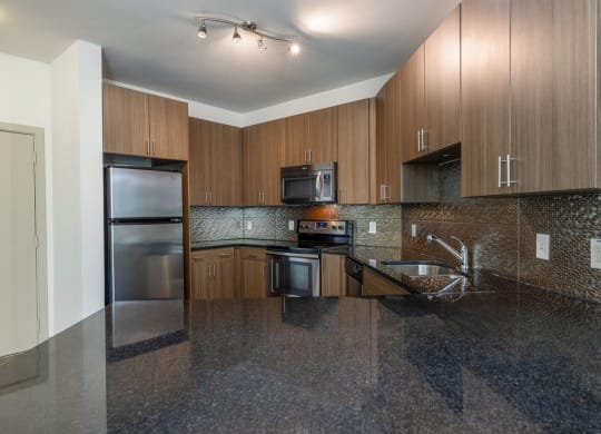 a kitchen with granite counter tops and wooden cabinets